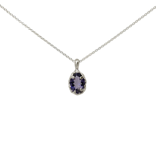 A silver necklace with an oval iolite gemstone pendant in a silver bezel setting, shown against a plain white background.