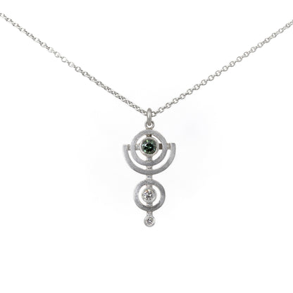 Silver necklace with a pendant featuring a green diamond on a white background
