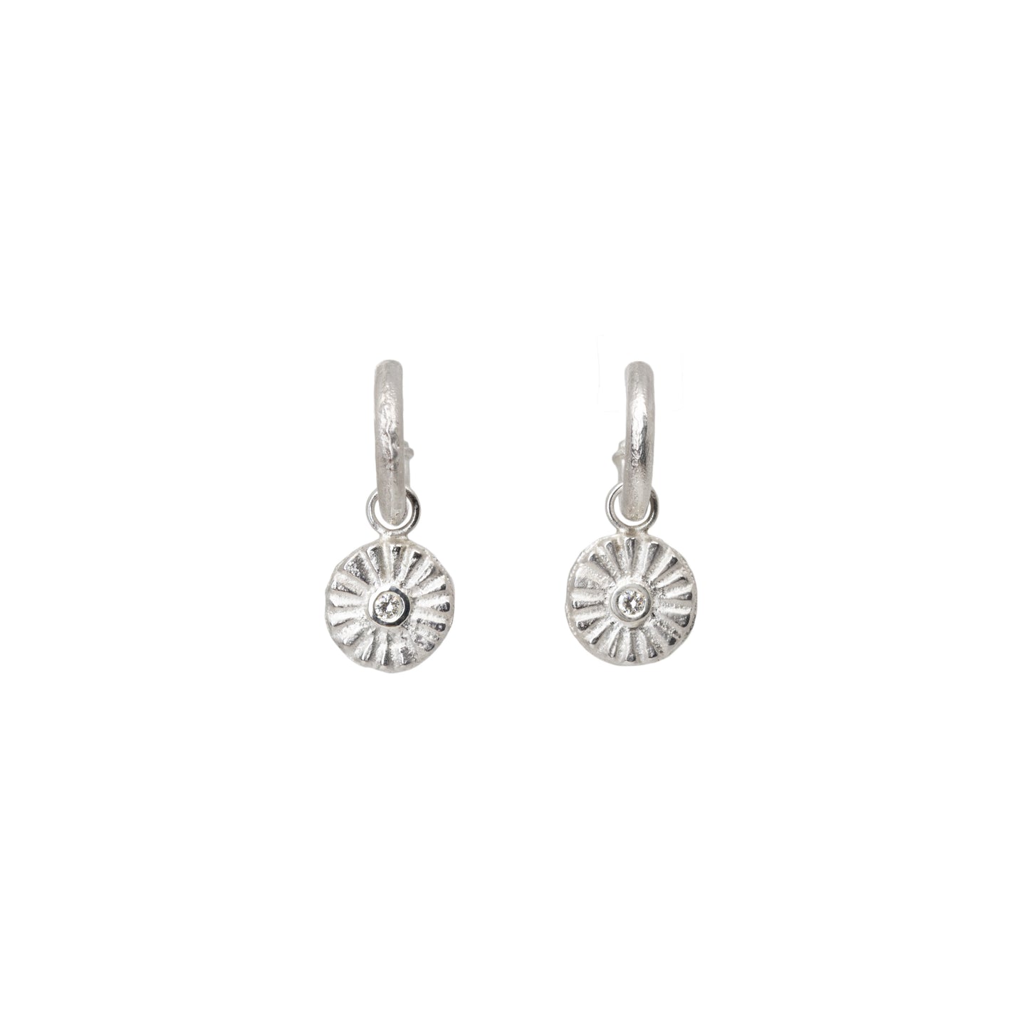 Pair of silver hoop earrings with circular diamond charms designs on a white background