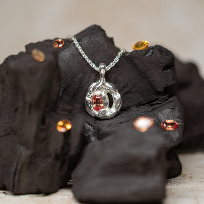 Silver pendant with orange sapphire on charcoal