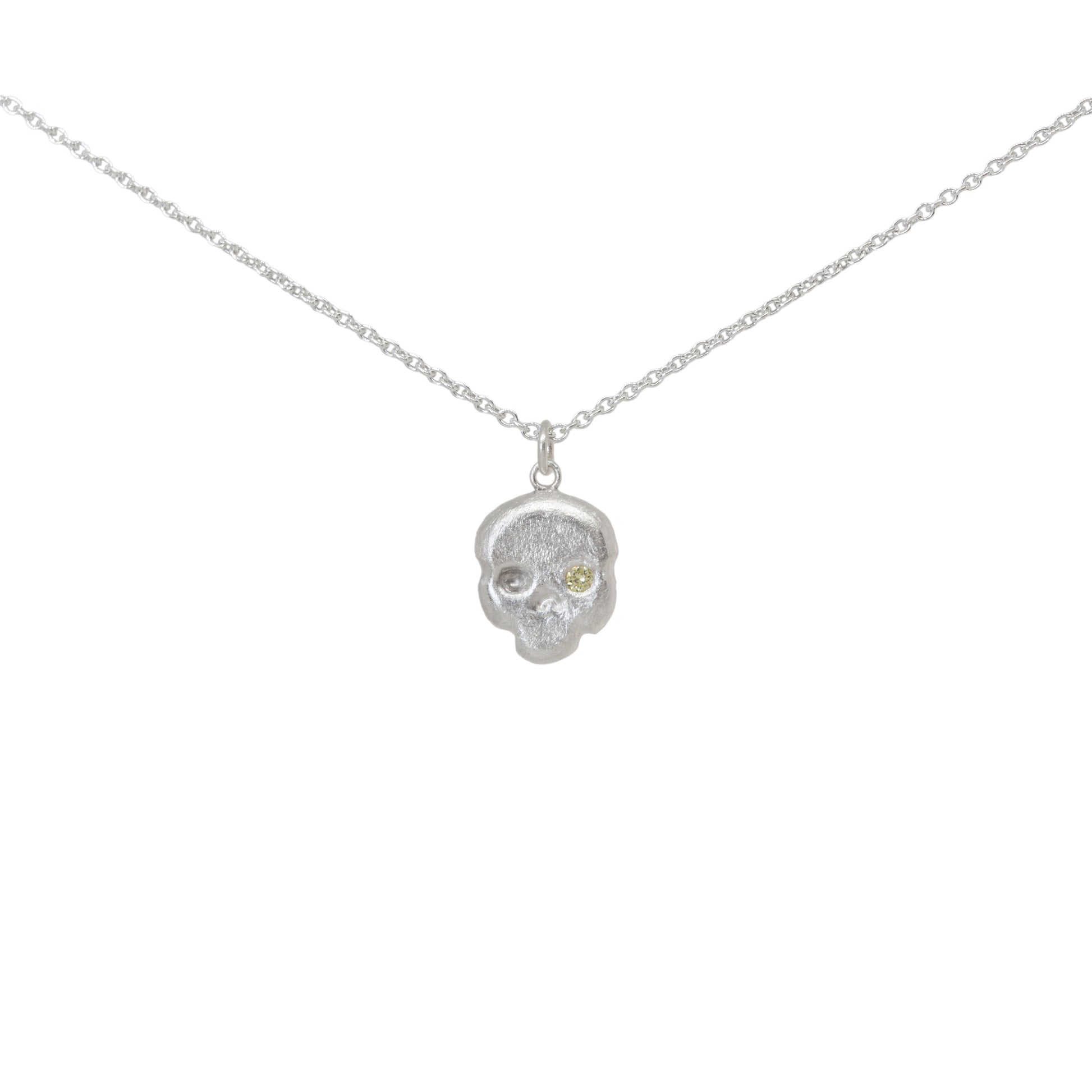 Sterling silver and yellow diamond skull pendant necklace on a white background