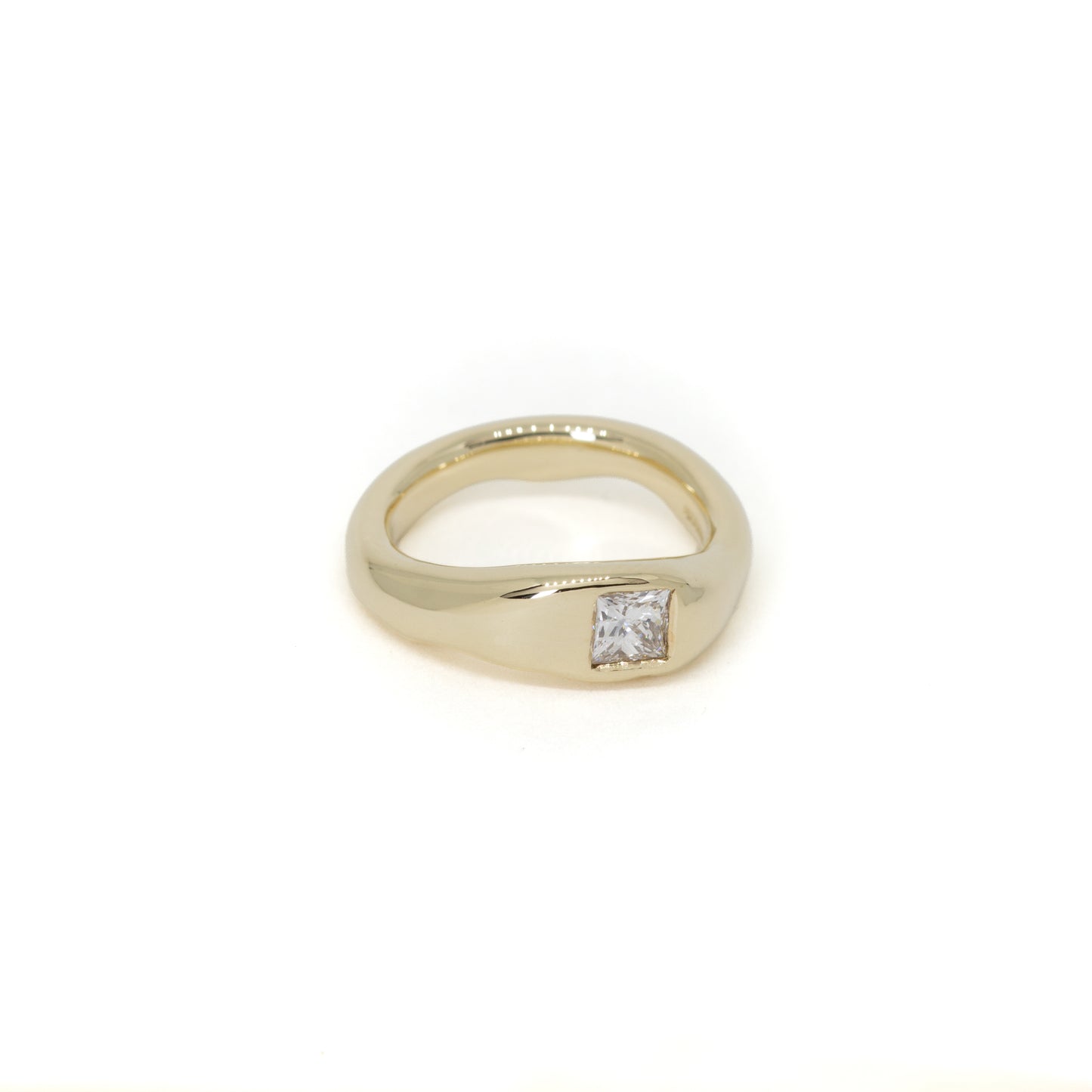 A yellow gold shaped wedding ring with a single princess-cut diamond flush set, shown on a plain white background.