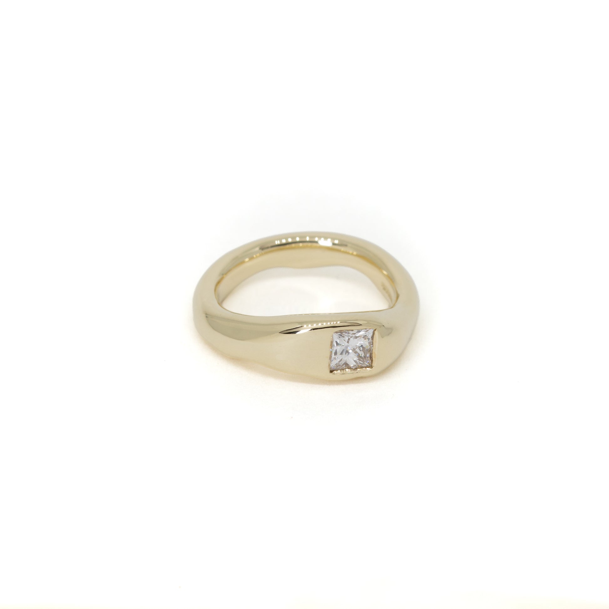 A yellow gold shaped wedding ring with a single princess-cut diamond flush set, shown on a plain white background.