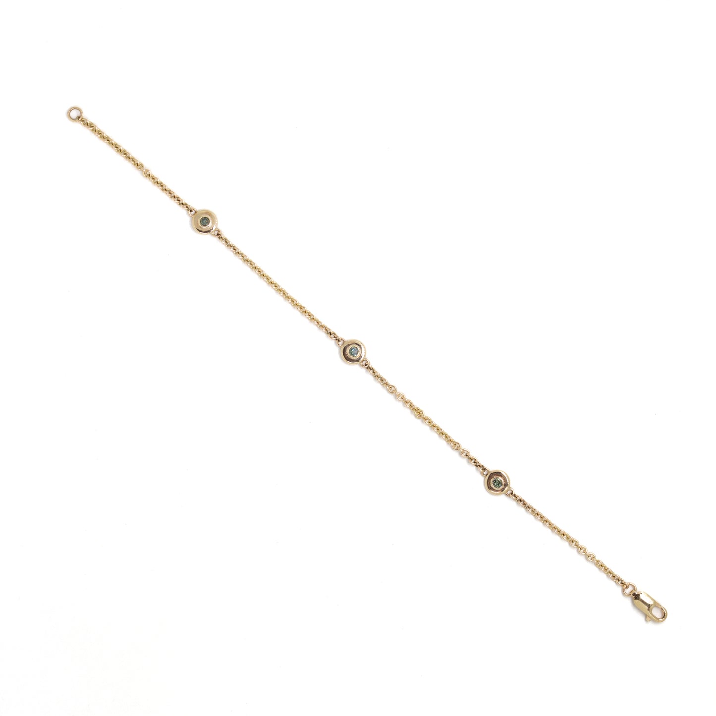 Gold bracelet with small round green diamond settings on a white background