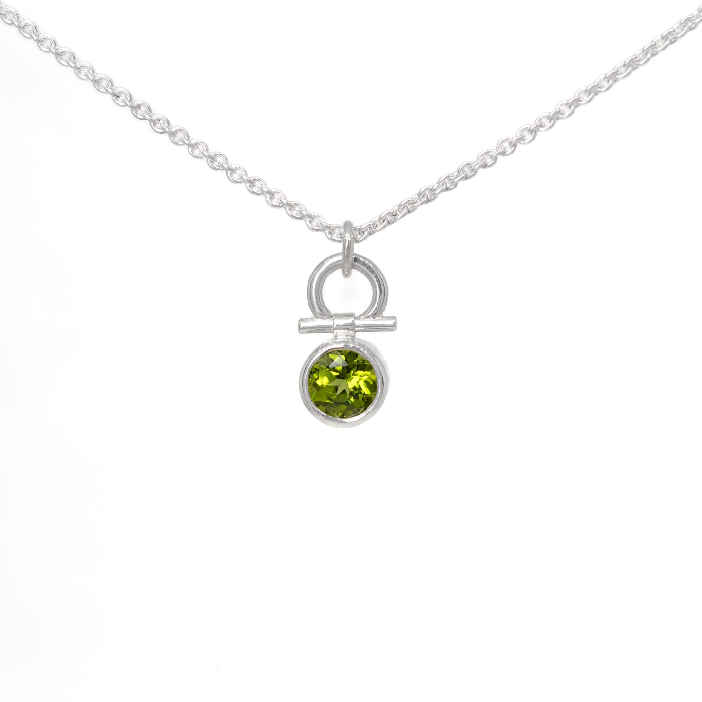 Silver necklace with a peridot gemstone pendant on a white background