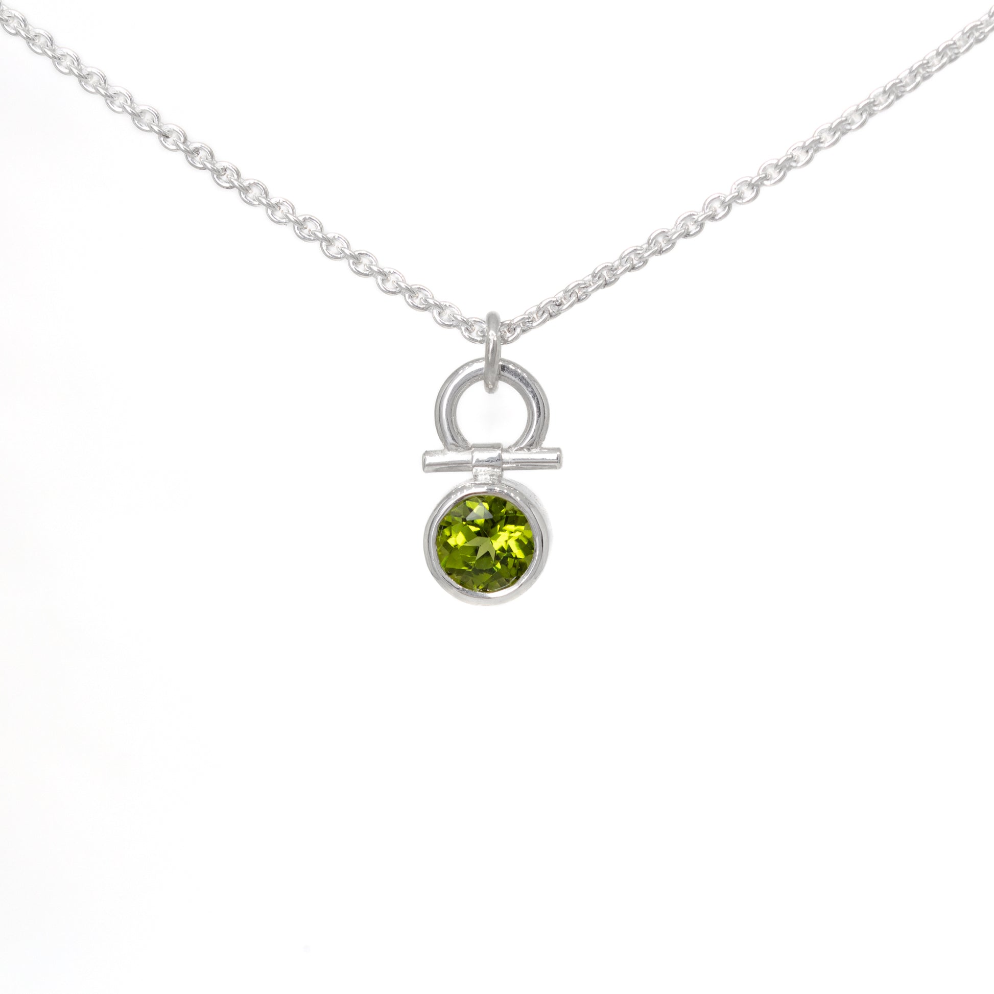 Silver necklace with a peridot gemstone pendant on a white background