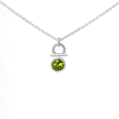Silver necklace with a peridot gemstone pendant on a white background