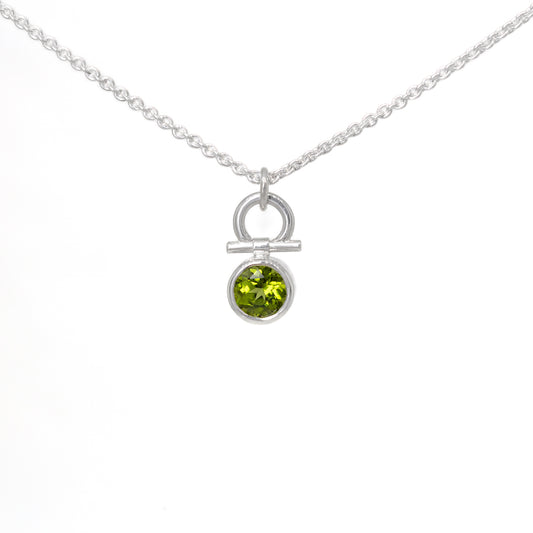 Silver necklace with a peridot gemstone pendant on a white background
